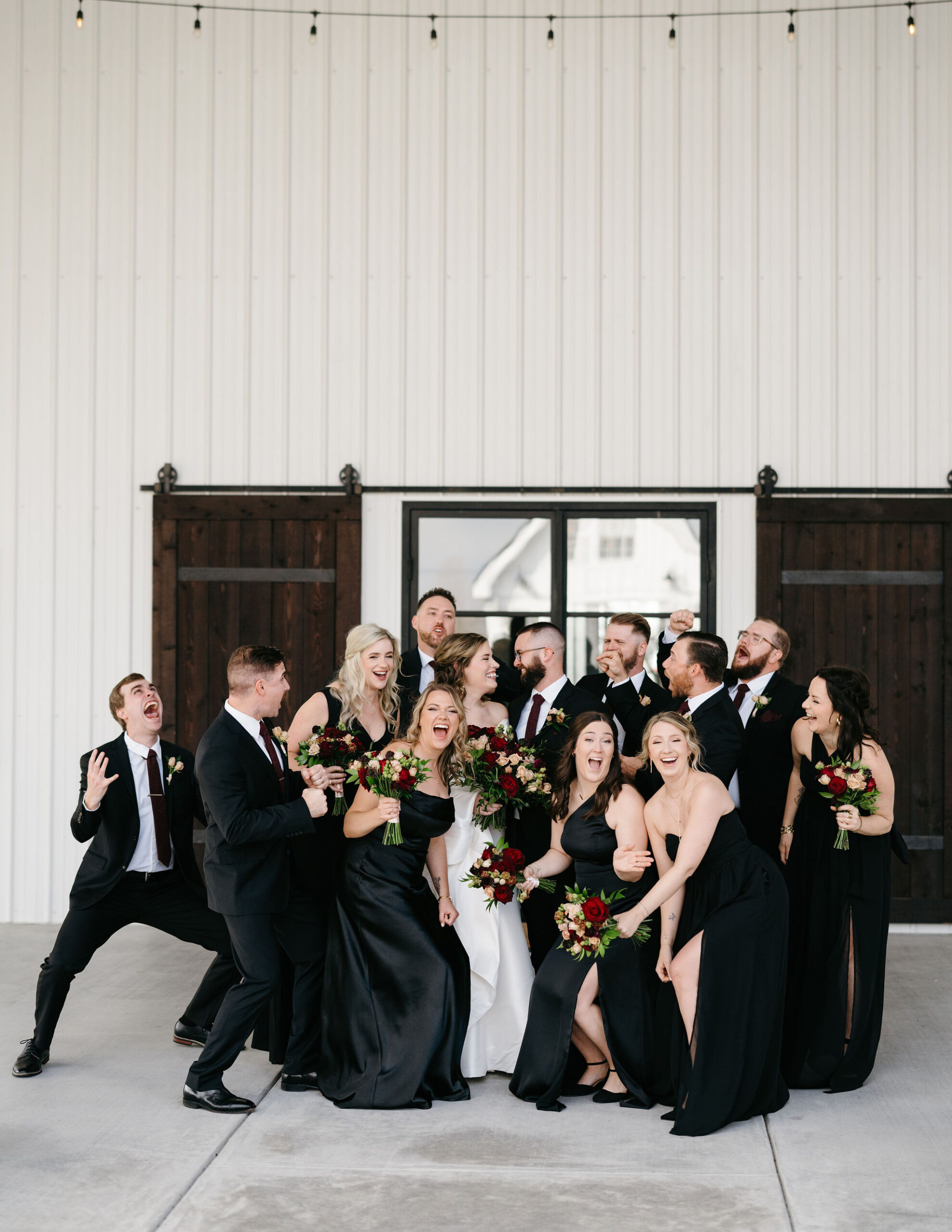 Bridesmaids in coordinated gowns sharing a polished, editorial wedding-day moment.