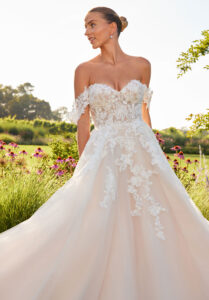 Morilee Saoirse A-line wedding dress with sheer sweetheart bodice, beaded floral lace appliqués, corset boning, and detachable off-the-shoulder sleeves