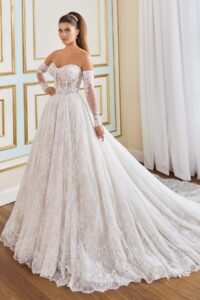 Ivory Martin Thornburg Begonia MT9112 A‑line wedding dress featuring a strapless sweetheart neckline, corded Chantilly lace bodice, glitter tulle skirt, corset waist detail, dramatic train, and separate long illusion sleeves